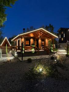 una grande casa in legno di notte con luci di Cave Chalet - Chalet for Two a Eptalofos