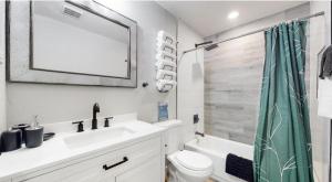 ein Badezimmer mit Waschbecken, Toilette und Spiegel in der Unterkunft Modern Family Home with Three King Beds Near VA & Anschutz in Aurora