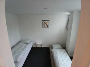 a small room with two beds and a table at Lejlighed ved stranden og centrum in Fredericia