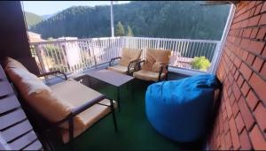 a balcony with a couch and a table and chairs at Apartman Nikola in Vlasenica