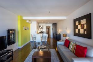 a living room with a couch and a tv and a table at Les Immeubles Charlevoix - Le 1176 in Quebec City