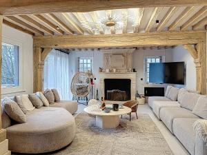 un soggiorno con due divani e un camino di Villa Elysia YourHostHelper a Touques