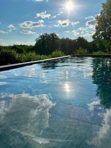 una piscina con il sole nel cielo di Villa Elysia YourHostHelper a Touques
