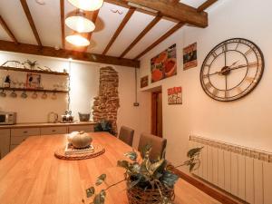 een keuken met een houten tafel en een grote klok aan de muur bij Baywatch St David's View in Lynton +20 foto's