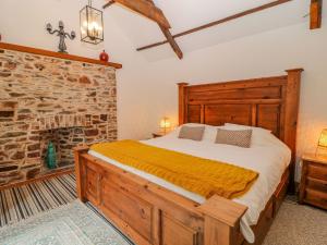 een slaapkamer met een bed en een stenen open haard bij Baywatch St David's View in Lynton