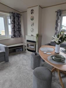 een woonkamer met een tafel en een open haard bij SummerBreeze Retreat in Hartley