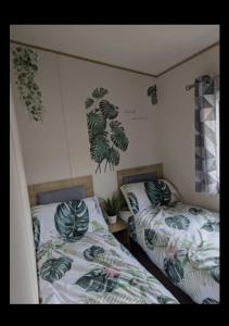 twee bedden in een kamer met planten aan de muur bij SummerBreeze Retreat in Hartley