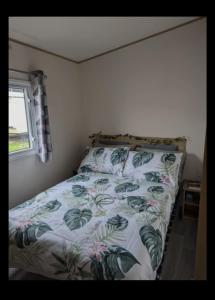 een slaapkamer met een bed met een bloemdekbed en een raam bij SummerBreeze Retreat in Hartley
