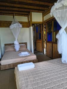 La SerenaにあるHOTEL Casa del Árbol ECOPARQUE CHINAUTAの部屋にはタオルが敷かれたベッドが2つある