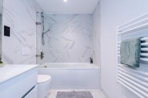 a white bathroom with a tub and a toilet at Birmingham City centre, Pool table, Spacious in Birmingham