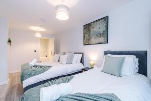 two beds in a room with white walls at Birmingham City centre, Pool table, Spacious in Birmingham