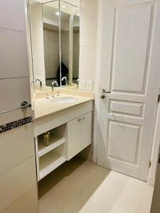 a white bathroom with a sink and a mirror at Check and Home - San Lorenzo - 2 Huéspedes con Pileta y Cochera in Mar del Plata