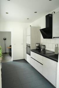 eine Küche mit weißen Schränken und schwarzen Arbeitsplatten in der Unterkunft Altstadt Apartment Deluxe 1 in Haltern + 7 Fotos