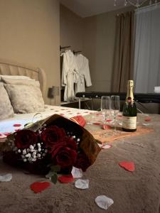 Pacy-sur-EureにあるUN COCON EN VILLE - chambre SPA chic et éléganteのベッド1台(シャンパン1本、ワイングラス付)