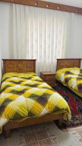 due letti uno accanto all'altro in una camera da letto di Şafak pansiyon 