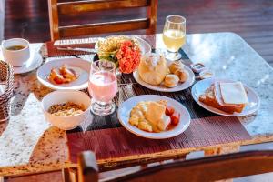 a table with plates of food and glasses of wine at VELINN Pousada Face Norte in Ilhabela