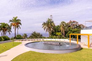 een zwembad in een park met palmbomen bij Acqua Mar in Funchal