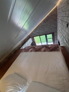 a large bed in a room with a brick wall at Bosch Rest in Pretoria