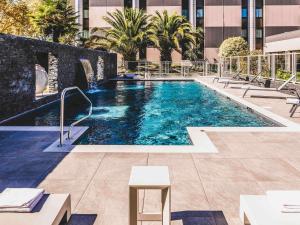 una piscina al costado de un edificio en Mercure Pau Palais des Sports, en Pau