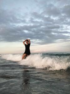 Eine Frau, die auf einem Surfbrett im Ozean steht in der Unterkunft Uncle Bob & Tere Beach House in Luna