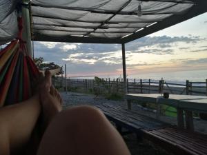 a person laying in a hammock looking at the ocean at Native Rooms in Luna