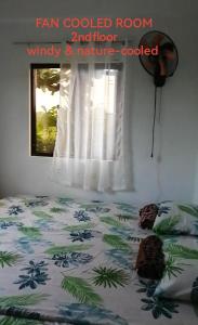 ein Schlafzimmer mit einem Bett mit einer Palme codierten Zimmer sqor sqor sqor in der Unterkunft Uncle Bob & Tere Beach House in Luna