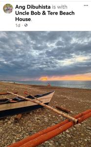 ein Boot am Strand mit dem Meer in der Unterkunft Uncle Bob & Tere Beach House in Luna