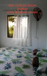 ein Schlafzimmer mit einem Bett und einem Fenster in der Unterkunft Uncle Bob & Tere Beach House in Luna