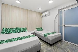 a room with two beds and a sliding glass door at Casa Hotel Ecosuite in Cali