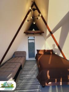 a attic room with a bed and a couch at Chalet Maranatha Vista Única Represa de Chivor in Macanal +23 photos