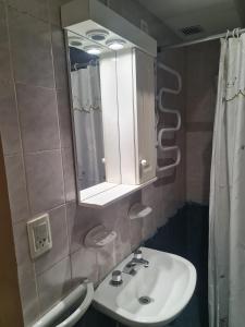 ein Badezimmer mit Waschbecken, Spiegel und Dusche in der Unterkunft Complejo Pasos Malos in Merlo