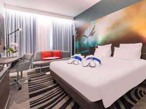 a hotel room with a bed and a desk at Novotel Milano Linate Aeroporto in Milan