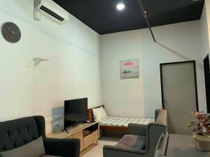 Sala de estar con cama y espejo en 2BR Airport Panoramic View Family Suite, en Bayan Lepas