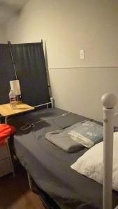 een slaapkamer met een bed en een tafel met een lamp bij A bed in Mike' s Home only 22 dollars a night in Texas City