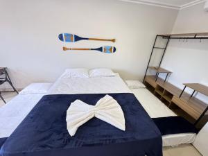 a bedroom with a bed with a bow tie on it at Orla Suítes in Porto Seguro