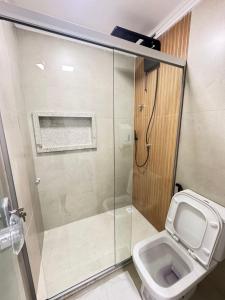 a bathroom with a shower and a toilet at Orla Suítes in Porto Seguro