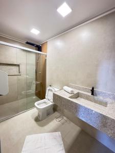 a bathroom with a toilet and a sink and a shower at Orla Suítes in Porto Seguro