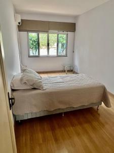 ein Schlafzimmer mit einem Bett und einem Fenster in der Unterkunft Descanso garantido no centro de Foz in Foz do Iguaçu