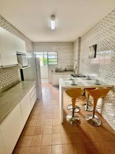 eine Küche mit einem Tisch und zwei gelben Hockern in der Unterkunft Descanso garantido no centro de Foz in Foz do Iguaçu