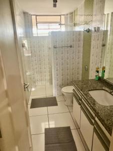 ein Badezimmer mit Dusche, Toilette und Waschbecken in der Unterkunft Descanso garantido no centro de Foz in Foz do Iguaçu