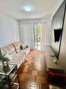 ein Wohnzimmer mit Sofa und Tisch in der Unterkunft Descanso garantido no centro de Foz in Foz do Iguaçu