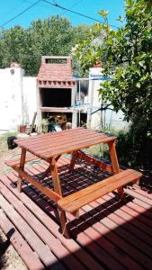 een houten picknicktafel bovenop een terras bij Duplex Luz de Sol in Las Toninas