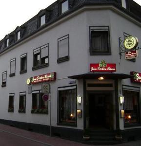 a white building with signs on the side of it at Hotel zum dicken Baum in Mayen