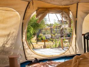 El RosarioLa Colmena Glamping Zangano的帐篷内部景象，帐篷顶部有一个圆形窗户。 更多96张照片
