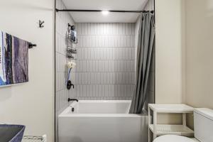 un bagno bianco con vasca e WC di Luxury 1BD Condo in LA with Rooftop City Views, Gym & Free Parking a Los Angeles Altre 31 foto