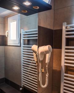 En el baño hay un secador de pelo colgado en la pared. en Pensiunea Taka, en Orşova