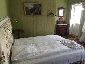 a bedroom with a bed and a lamp at Gjestehuset IBSEN in Grimstad