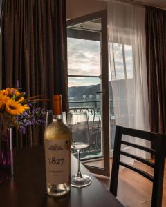 Una botella de vino sobre una mesa con una copa. en Pensiunea Taka, en Orşova