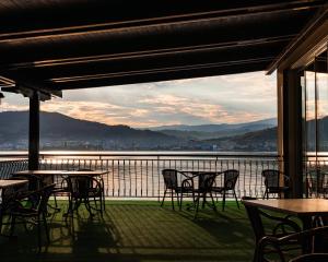 a patio with tables and chairs and a view of the water at Pensiunea Taka in Orşova