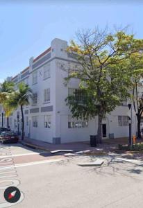 a white building with a tree in front of it at Knickerbocker 102 in Miami Beach